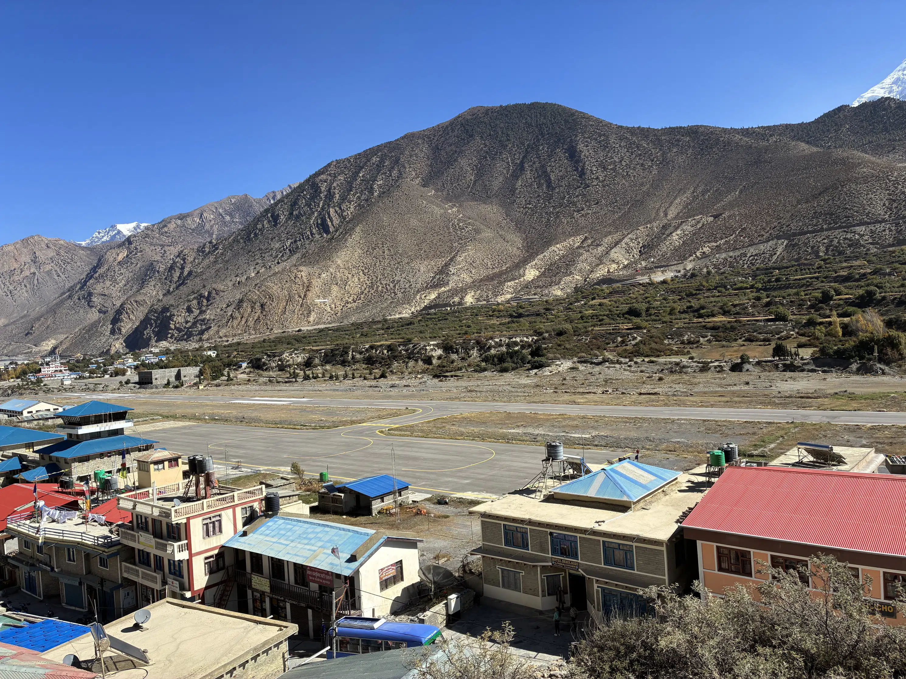 Traditional Upper Mustang village with mountain views and blue-roofed houses